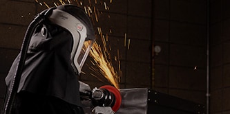 Image d'un ouvrier masqué, utilisant un disque de précision ultrarésistant Scotch-Brite™
