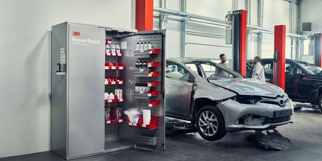 2 personnes parlent près d'un véhicule cabossé et d'une armoire 3M™ RepairStack™ ouverte.
