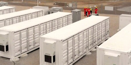 Image de travailleurs près d'un parc de batteries
