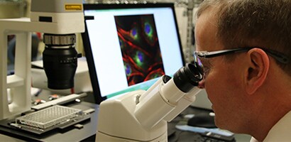 Mark Tomai, scientifique chez 3M, regarde dans un microscope
